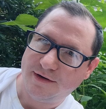 Christopher Gabriel Brown, outdoors among green leaves, summer 2026